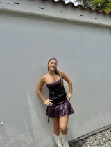 Vestido corto con estampado de rayas horizontales en tonos grises y negros. Diseño con escote halter que se ata al cuello, abertura central en el busto y falda corta con volado.