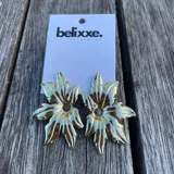 Par de aros colgantes dorados con forma de flor de hojas puntiagudas.