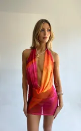 Minivestido con estampado degradado en tonos naranja y fucsia, escote halter y espalda descubierta.