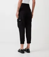 Pantalón zanahoria negro de viscosa, con cintura alta, bolsillos cargo con botón dorado y ruedo con dobladillo. 