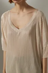 Blusa negra de poliéster con textura plisada y escote en V.