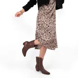 Bota texana de cuero negro, con caña media, punta fina y taco bajo. Diseño con costuras decorativas en el empeine y laterales.
