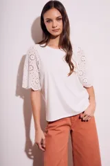 Remera blanca de algodón peinado con calce oversize y mangas cortas con detalle de calados.