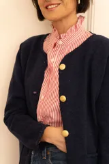 Camisa de manga larga con cuello con volados y estampado de rayas verticales rojas y blancas.