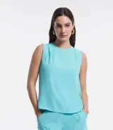Blusa sin mangas color celeste, de crepé, con cuello redondo, pliegues en uno de los hombros y cierre trasero por cremallera con detalle de aro en el tirador.