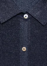 Cárdigan azul con brillos, de tejido de punto fino, cuello camisero y cierre frontal con botones.