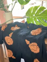 Cárdigan blanco de lana merino con bordados de flores color marrón.