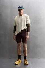 Camiseta color crema de corte holgado, cuello redondo y manga corta. Presenta un pequeño estampado con texto en el lado izquierdo del pecho.