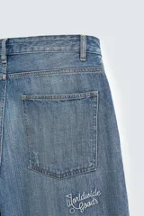 Pantalón de jean azul de corte amplio, con roturas y lavado gastado.