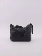 Cartera de cuero negra con correa regulable para usar al hombro o cruzada. Tiene un bolsillo espacioso con cierre que divide el interior en tres compartimentos.