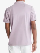 Chomba manga corta color lila con cuello clásico y tapeta de dos botones. Tiene el logo de Calvin Klein bordado en el pecho. Corte regular.