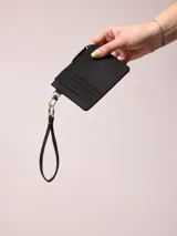 Billetera azul de poliuretano con cierre y correa de mano.