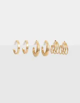 Set de tres pares de aros dorados: dos pares de argollas de diferentes tamaños y un par de aros con diseño de espiral triple.