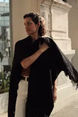 Ruana tejida en telar con lana merino 100% natural, color negro, con flecos en los bordes.