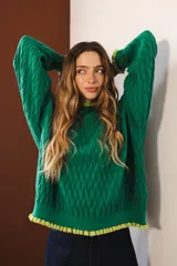 Sweater tejido rojo con cuello alto y puños con volados azules.