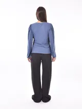 Remera azul piedra de punto canalé con mangas largas abullonadas.