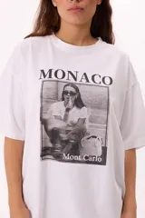 Remera blanca de algodón, corte oversize, con estampa fotográfica en blanco y negro con la leyenda "Monaco" y "Mont Carlo".
