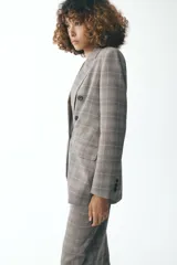 Blazer de Zara Woman Collection, con cuello solapa y manga larga. Tiene bolsillos delanteros y cierre cruzado con botones.
