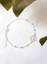 Pulsera plateada con cadena de eslabones y bolitas, con dije redondo de San Benito.
