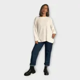 Buzo tejido con escote a la base, hebra en relieve y brillo, ideal para un look sofisticado y versátil.