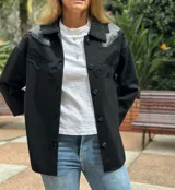 Camisa negra de lana con bordados en cuero en hombros y bolsillos.