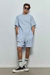 Short celeste de felpa liviana con cintura elástica ajustable con cordón, bolsillos laterales y bolsillo trasero.