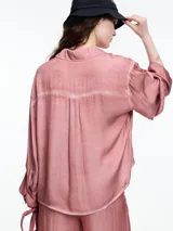 Camisa gris de manga larga confeccionada en viscosa teñida en frío, con efecto gastado. De corte relajado, con bolsillo delantero y puños amplios.