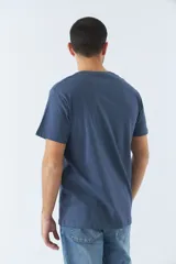 Remera azul de algodón con cuello redondo y estampado frontal con nombres de ciudades: Berlín, Nueva York, Dubai, París y Shanghái.