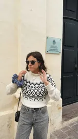 Sweater marrón de punto con cuello alto y diseño geométrico en blanco y negro.