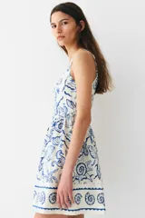 Vestido corto de algodón con estampado de motivos marinos en azul, con costuras estilo corset adelante y atrás. Modelo de cuerpo entallado con breteles anchos, escote cuadrado y cierre oculto con corchete en la espalda. Costura fruncida en la cintura y pollera con vuelo. Cuerpo forrado.