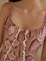 Malla enteriza negra con escote cuadrado, breteles anchos y espalda semi alta. Presenta un corte vertical central con volados y estampado animal print.