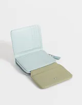 Billetera colorblock de cuerina con solapa con broche a presión, cierre y tirador.