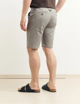 Bermuda de gabardina color verde con bolsillos laterales y traseros.