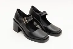 Guillermina de cuero negro con punta cuadrada, taco bloque y correa sobre el empeine con hebilla dorada.