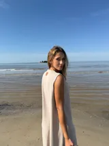 Vestido midi sin mangas color beige, con corte recto y detalle de franja vertical marrón en el centro.