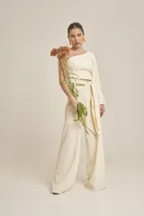 Top color crema de corte cropped, con un solo hombro y manga larga acampanada.