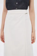 Falda midi de jean color blanco, con corte evasé y ruedo desflecado.