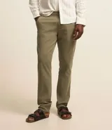 Pantalón de vestir color marrón, de corte recto, con bolsillos laterales y traseros. Se ajusta a la cintura con cinturón de cuero marrón.