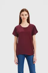 Remera color cereza con cuello redondo y mangas cortas con detalle de calado en los hombros.