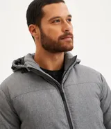 Campera deportiva azul marino con capucha ajustable, cuello alto, cierre frontal con cremallera y bolsillos laterales con cremallera.