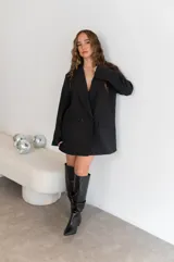 Blazer gris de corte clásico con solapas de muesca, cierre frontal con dos botones y bolsillos laterales con solapa.