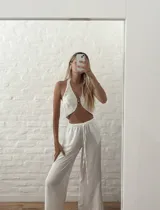 Pantalón blanco de tiro alto con corte palazzo y cordón ajustable en la cintura.