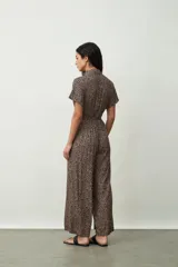 Mono largo negro de corte palazzo con camisa de mangas cortas con botones y lazo en la cintura.