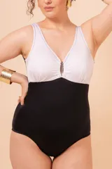 Malla entera de lycra negra con parte superior blanca y aplique metálico en el escote.