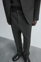 Pantalón de vestir de corte slim fit, color gris oscuro con micro estampado a cuadros. Cuenta con bolsillos laterales y traseros de doble vivo con botón. Cierre frontal con cremallera y botón.