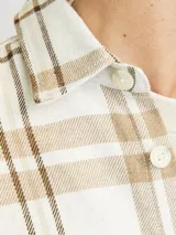 Sobrecamisa de manga larga color crudo con patrón a rayas en tonos marrones, cierre con botones y bolsillos en el pecho.