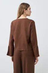 Blusa color chocolate de lino con escote en V y lazos para atar.
