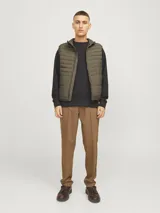 Chaleco acolchado verde militar sin mangas, con cuello alto, cierre frontal con cremallera y bolsillos delanteros.