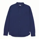Camisa de popelina verde con cuello abotonado, cierre frontal con botones, bolsillo de parche en el pecho izquierdo, mangas largas con trabillas para enrollar y dobladillo camisero.