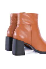 Botines de cuero color caramelo, con caña media, cierre lateral y tacón bloque negro de aproximadamente 7 cm.